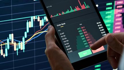 Photo of an investor about to place a stock market order on their phone.