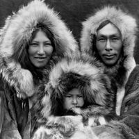 An Eskimo family wears fur parkas.