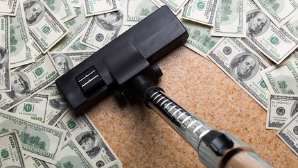 Money on the floor vacuuming with vacuum cleaner